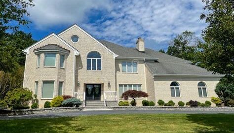 A charming suburban house in New Jersey with a well-maintained lawn.